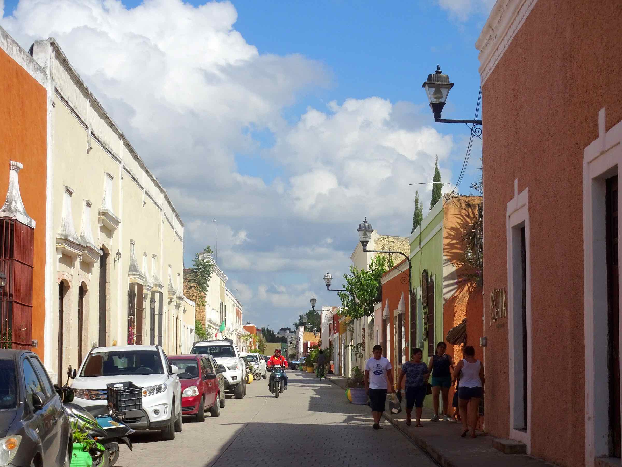 Calzada de los Frailes en Valladolid: calle empedrada de casas coloniales de colores, con gente caminando