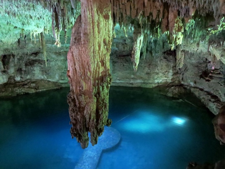 Cenote Suytun: columna de piedra sobre agua azul iluminada