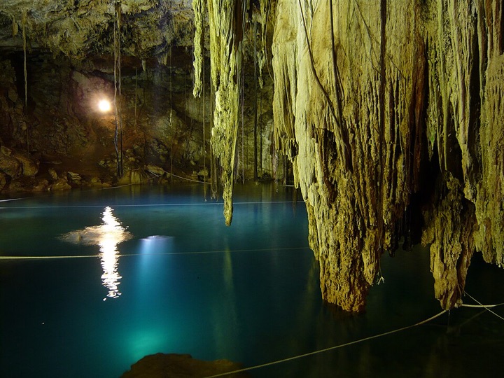 Cenote Xkekén: caverna con estalactitas sobre agua azul